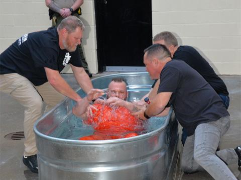 Jason Campbell, from left, Rev. Scotty Mathis, (hidden) and Rev. Chan Mitchell baptized Kenneth Eaton at the conclusion of the Better Man graduation ceremony at the Fannin County Jail Sunday evening, September 29. Eaton was one of several inmates who asked to be baptized.