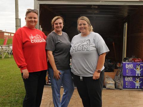Monica Hicks, Heather Cochran and Megan Mosley, from left, take a moment from loading donations for Copper Basin Recreation Association’s relief efforts for Western Carolina Tuesday, October 1. They ended up filling two trailers and trucks full of donations, which they took early Friday morning. The league competes against several teams that were affected by Hurricane Helene’s tropical storms.