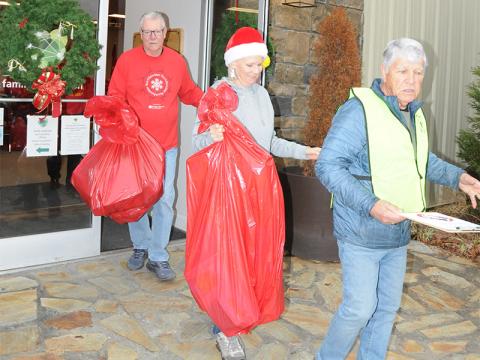 Fannin County Toys for Tots volunteers Wayne Murphy, Sandy Mote and Joel Warner, from left, bring out some orders to a local family Friday, December 20.