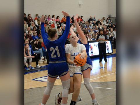 Callie Ensley fights her way between two defenders for the Fannin County Lady Rebels in post season action.