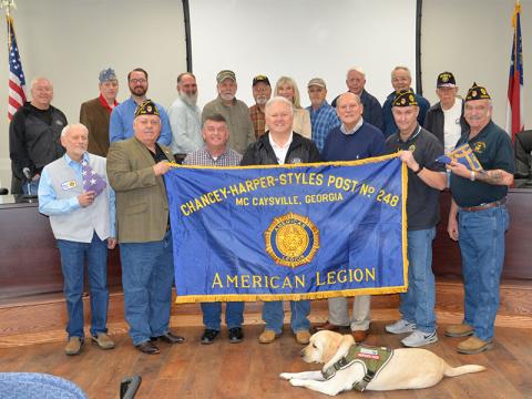 A trio of flags are destined to be framed and hung in the commission conference room in the Fannin County Courthouse. Shown during the presentation are, from left, front row: Walt Polk, James Callender, Jaime Hensley, Johnny Scearce, Glenn Paterson, John Tucker and Bruce Fowler; and, back, John Chastain, Danny Drake, Michael Earley, Tim Doherty, Jerry Chastain, Bud Chastain, Susan Kiker, Terry Arp, Larry Collis, Billy Wayne Chastain, and Bruce Weber.