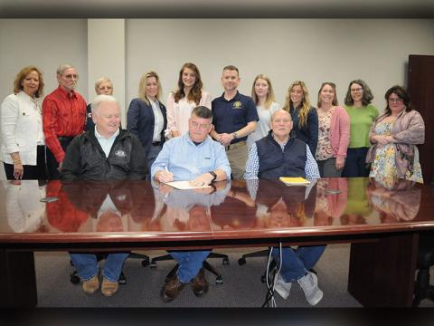 News Observer Photo/Jackson Elliott Fannin County Commission Chairman Jamie Hensley signs a National Crime Victims’ Rights Week proclamation. Those attending the event included various representatives of District Attorney Frank Wood’s office including those working in the Victim Services program. Shown during the proclamation signing are, from left, front row: commissioners Johnny Scearce, Hensley, and Glenn Patterson; and, back row, Joan Rutledge, Ferrell Yates, Carmen Yates, Marianne Gelakoska, Anna Poste