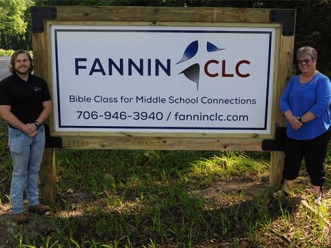 Jared Herum and Tina Lee display the sign for the new Fannin Christian Learning Center.