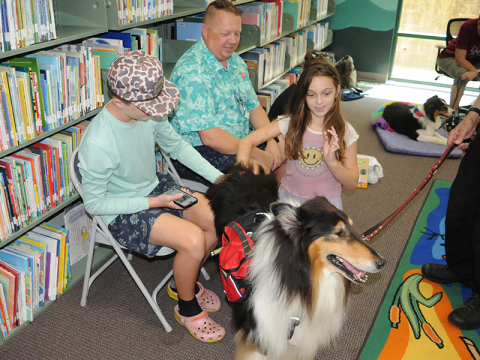 A family meets Calder the Reading Dog at the Fannin County Public Library. From left are Joshua Potters, Brian Potters and Isabella Potters.