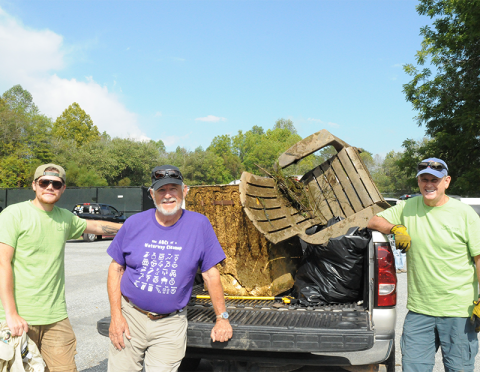 Carter Ott, Harmon Smith and Steve Williamson, from left, found a chair and what seems to be an old refrigerator in the river during Rivers Alive at Tammen Park September 27.