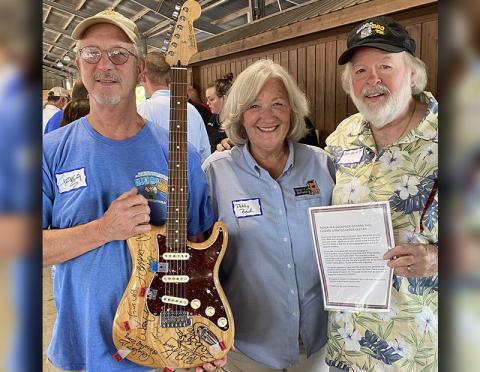 Greg Spencer, Debby Beck and Carl Pruett, from left, are shown with the autographed Fender six-string Stratocaster.