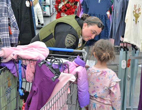 Sergeant Brittny Depuy with the Fannin County Sheriff’s Office Detention Center helps this young girl find some new clothes during Shop With A Cop.