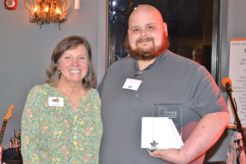 Snack in a Backpack board Secretary Mary Langford presents Tristin Davenport of Blue Ridge Food Lion the Business Champion award at the organization’s Champions for Children Fundraiser March 2.