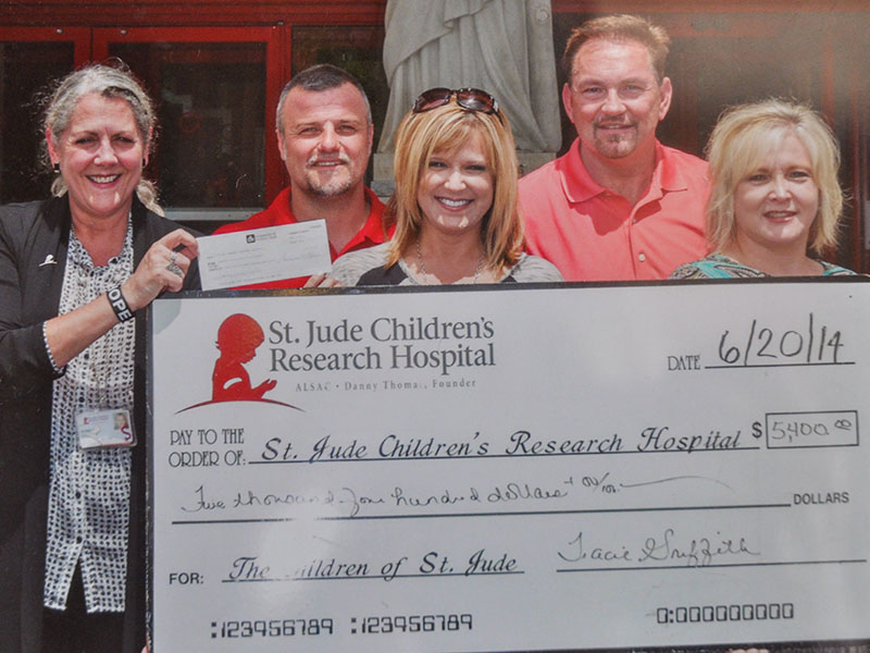 Tracie Griffith, center, holds a donation check in the amount of $5,400 to St. Jude Children’s Research Hospital. Standing with her are, from left, a St. Jude representative, husband Mark Griffith, CJ Green and Sherry Green.