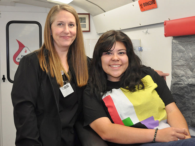 Blood Assurance’s Donor Care Specialist, Ava, assists Fannin County High School student Kristen Lopez before she donates blood.