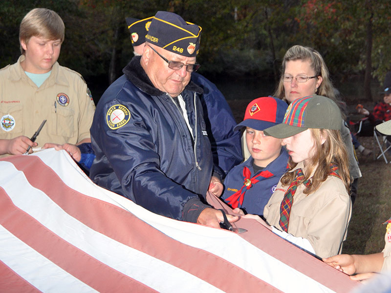 Veteran Richard Crosley retires the stripes by cutting them off one by one during a Flag Retirement ceremony at Ron Henry Horseshoe Bend Park Tuesday, October 22. Members of local veterans organizations, the North Georgia Honor Guard and scouts conducted the patriotic ceremony.