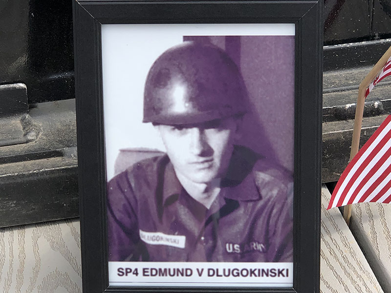 Mark Dlugokinski told the story of his uncle Edmund who was killed tending to a wounded comrade. Mark placed this picture at the base of the panel on the Vietnam Traveling Wall Memorial containing Edmund’s name.