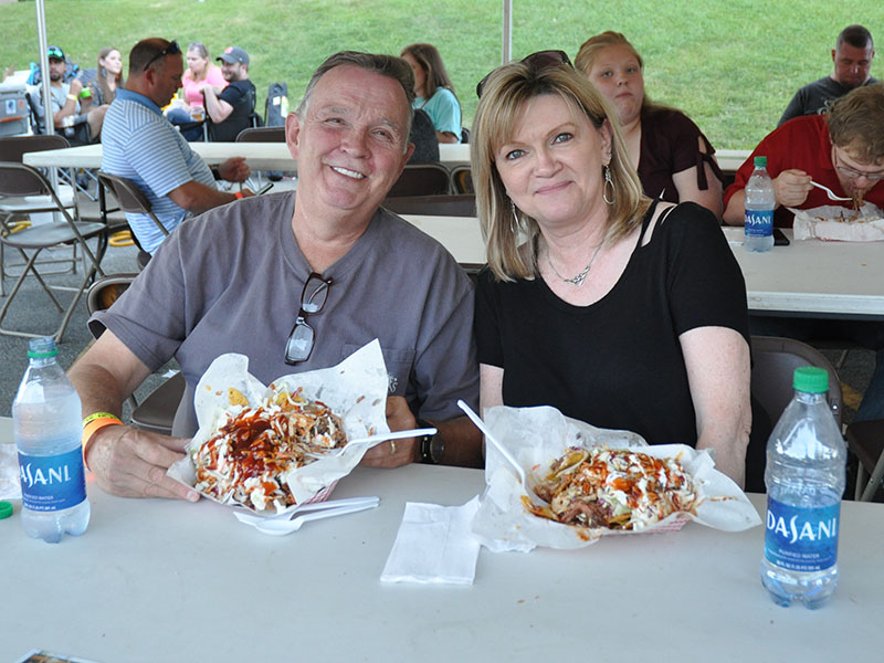 Mike and Ginger Epperson chow down on piles of barbeque nachos as blues music filters over the air during the Blues & BBQ Festival.