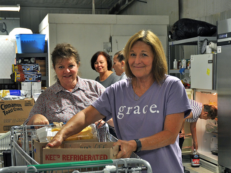Family Connection food pantry volunteers Priscilla McDonald, left, and Meredith Yacavone work to unload and organize food in the new, larger food storage area at the organization’s new building at the end of Industral Road in Blue Ridge.