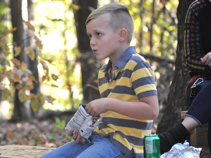 East Fannin Elementary School student Seth Owenby ate a campfire dinner while listening to a story in the school’s outdoor classroom.