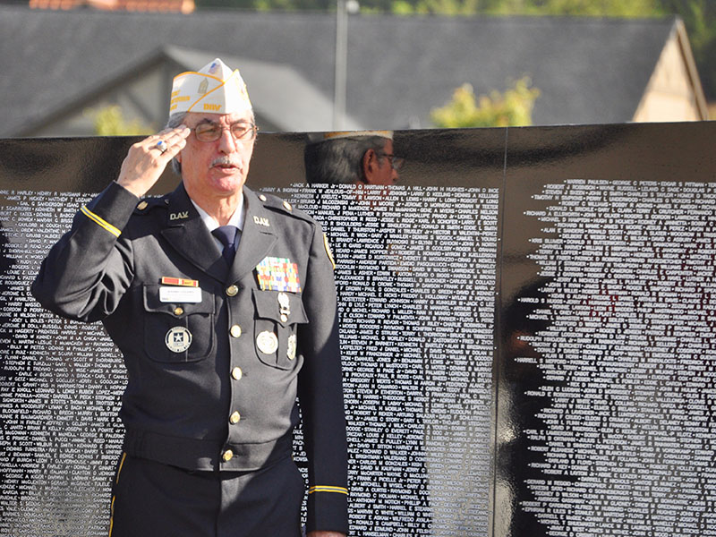 Veteran Manny Lozano salutes the American flag as the North Georgia Honor Guard posted the colors during the The Vietnam Traveling Memorial Wall memorial service.
