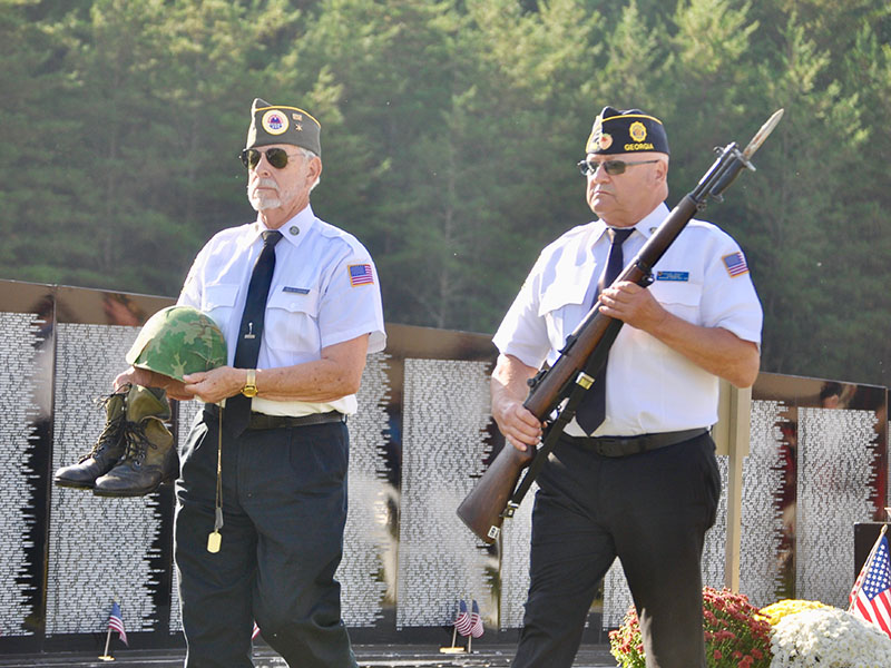 North Georgia Honor Guard members Steve Strickland, left, and Richard Crosley carry the boots, helmet, dog tags and rifle for the tribute to the fallen soldier during the The Vietnam Traveling Memorial Wall memorial service.