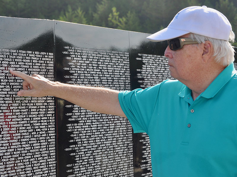 Jim Rozelle finds the names of fallen Vietnam War soldiers following the The Vietnam Traveling Memorial Wall memorial service.