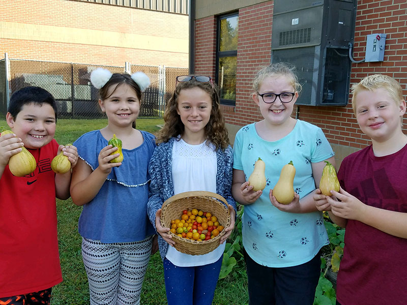Fourth grade West Fannin Elementary School students recently harvested tomatos and squash to be used in dishes at Lit’l Pond Hospitality Group restaurants. Shown are, from left, Reed Chancey, Bea Painter, Abigail Gardner, Skylar Gazaway and Luke Sosebee.