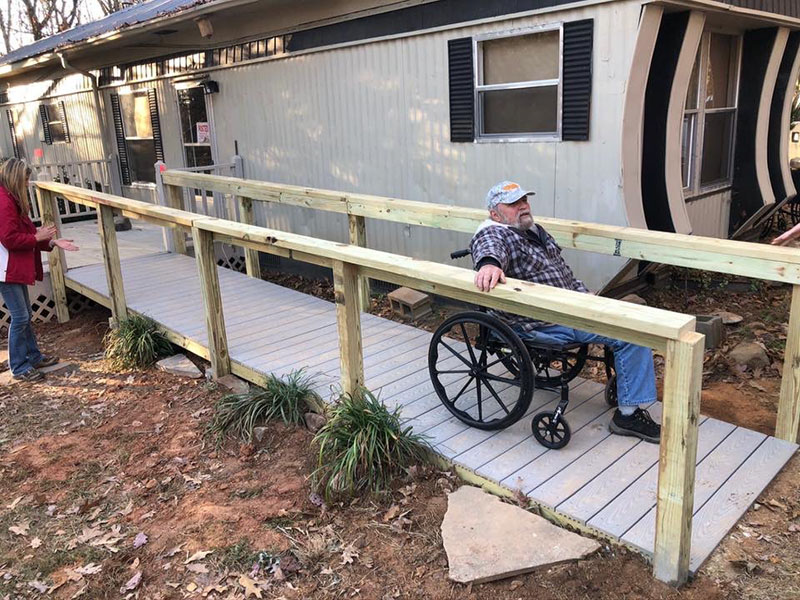 Roger Dionne puts his new wheelchair ramp to the test. The ramp was built using materials donated by Home Depot for the The Vietnam Traveling Memorial Wall that had been salvaged after the wall was taken down.