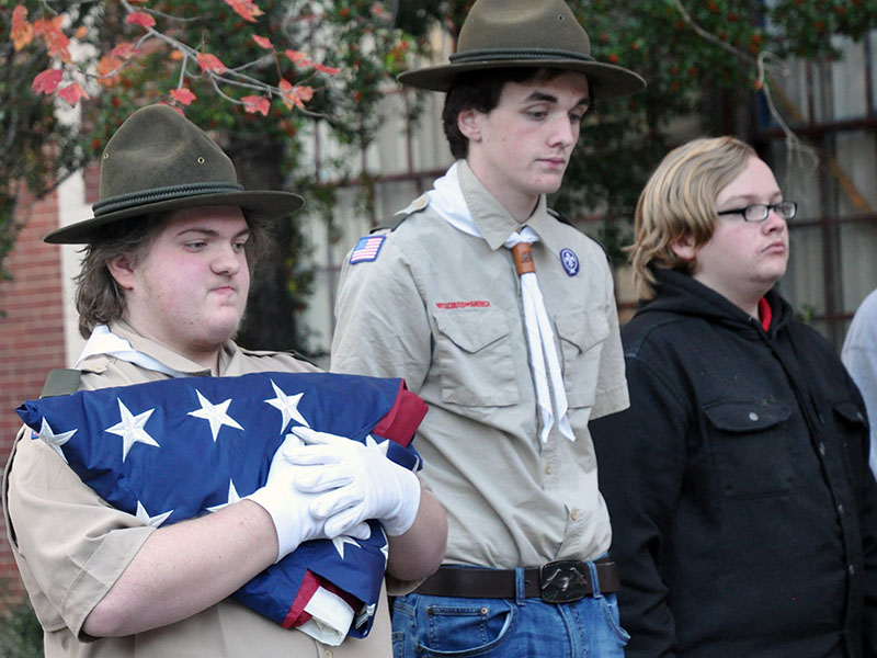 Jonothon Payne, Ducktown Boy Scout Troop 14’s assistant scout master, holds the first flag to be retired the evening of Saturday, November 9. Shown with Payne are, from left, Matthew Payne and Dakota Harris.