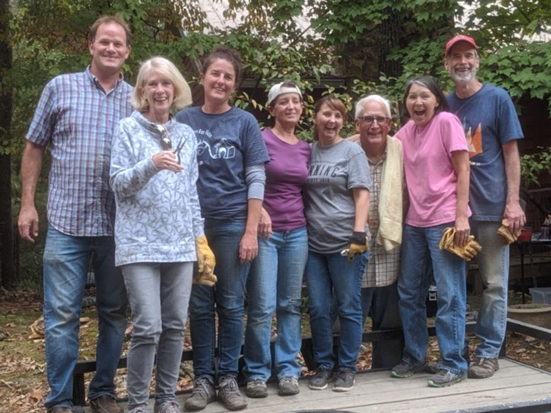 Freedom for Fido volunteers Spencer Brown, Elizabeth Young, Trish Sigman, Carol Shannon, Jackie Gilbert, Tim Pauley, Tammy Vaughn and Mike Vaughn, shown from left, prepare to build a fence for a family in the community. Gilbert founded the non-profit group to help local dogs who live their lives outside on chains.