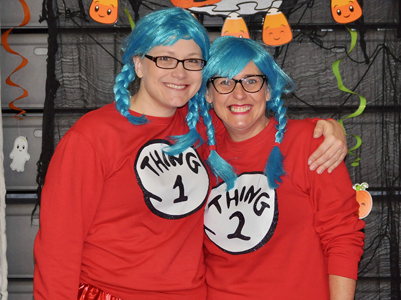 Thing 1 and Thing 2, also known as Brooke Owens, left, and Katie Turner, pass out Halloween candy to students at West Fannin Elementary School.