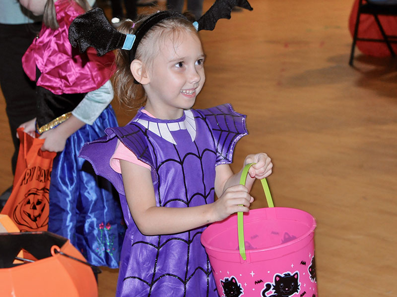 Annabella Perkins holds out her bucket for candy at West Fannin Elementary School.