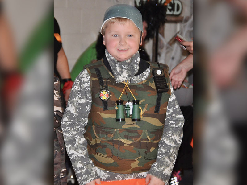Army soldier, Will Henderson, finds candy at West Fannin Elementary School’s trick-or-treating event.