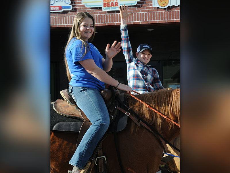 Two young riders wave to the crowd lining Blue Ridge Drive during the Copperhill Kiwanis Club Christmas Parade.