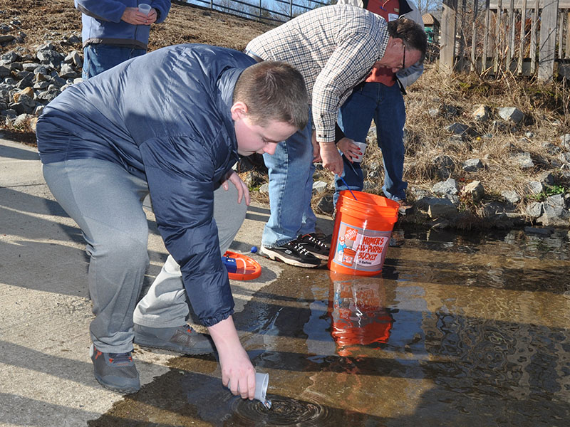 The Blue Ridge chapter of Trout Unlimited facilitated a trout life-cycle program, Trout in a Classroom, at Fannin County Middle School where the eighth-graders raised trout from eggs and then released them into the Toccoa river, December 18. Shown is Ridge Stevens pouring a trout fingerling into the chilly water.