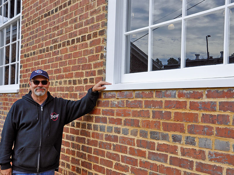 Rush shows off the new 12-paned windows that were custom built to replicate the original windows in the Hoist House.