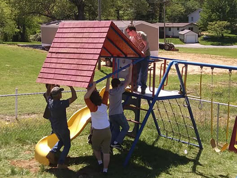 Andrew Monroe and fellow Boy Scouts place a roof on the playset for Fannin County Preschool’s playground.