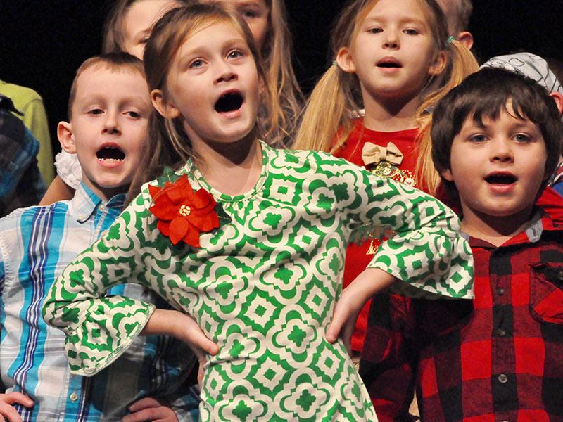 East Fannin Elementary School student Lily Eckels swayed back and forth to the beat of a Christmas song during the school’s White Christmas program. Shown behind her are Jake Dyer, left, and Camden Carver.