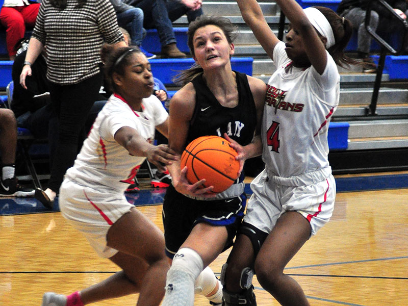 Lady Rebel Becca Ledford fights through two GAC defenders in recent action for the Lady Rebels basketball team.