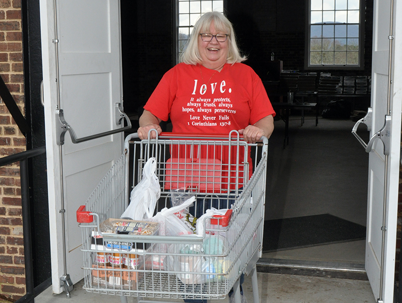 Kathi Hensley was all smiles as she went about getting groceries to families last week at the Hoist House.