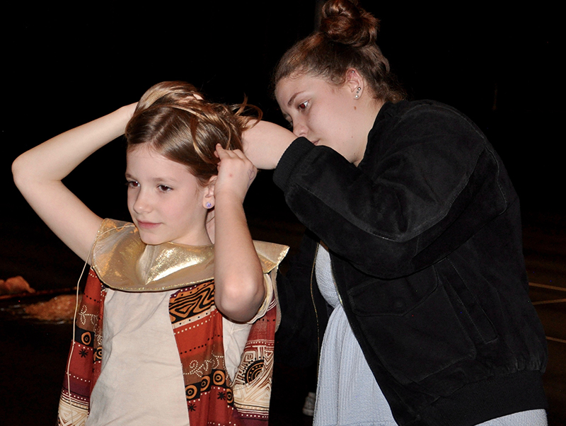 West Fannin Elementary Student Allie Rosa Radabaugh has her headset adjusted by Fannin County High School student and theater tech Hailey Fields during a dress rehearsal for The Lion King Wednesday, March 4.