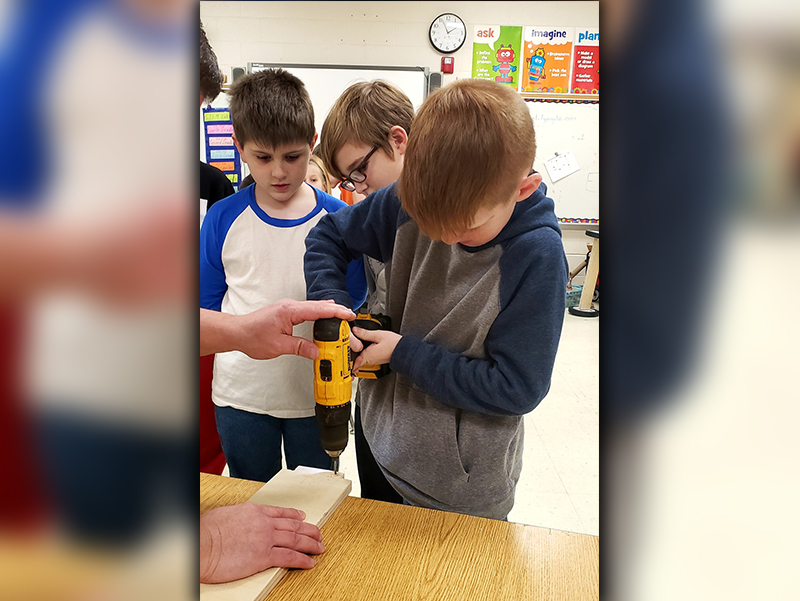 Mitchell Martin, Christian Highley and Brody Golden, from left, worked to get parts ready for a soap box derby car at East Fannin Elementary School.