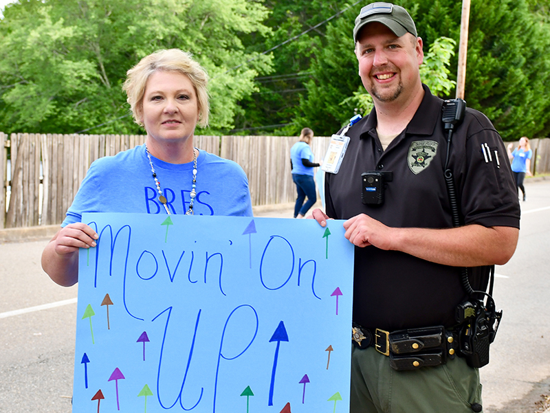 Blue Ridge Elementary School Student Information Specialist Lisa Jackson and School Resource Officer Jim Burrell celebrate the fifth graders’ transition to middle school during the school’s Fifth Grade Drive-Thru Parade Tuesday, May 19.