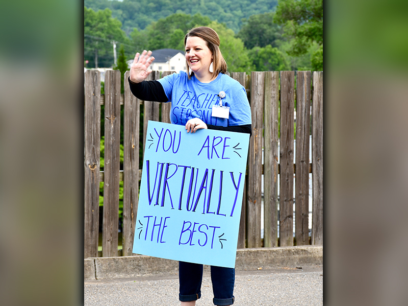 Blue Ridge Elementary School Counselor Trista Ragsdale waves to fifth grade students as they drive through the parent pick-up section at the school.