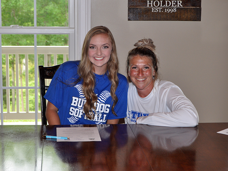 Copper Basin Lady Cougar Regan Holder signed a scholarship to play softball at Tennessee Wesleyan University Wednesday, June 17. Holder, left, smiles with TWU Assistant Coach Leah Thompson.