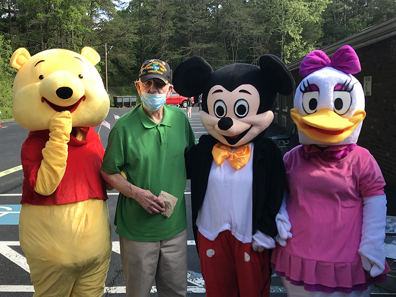PruittHealth - Blue Ridge held a socially distanced drive-thru parade to lift the spirits of their residents Monday, May 25. Chuck Fenn is shown with characters: Winnie the Pooh, Mickey Mouse and Daisy Duck.