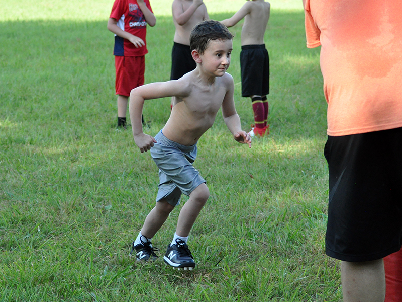 Kayson Coleman charges a tackling dummy during the Cougar’s five and six year old football conditioning Thursday, July 16.