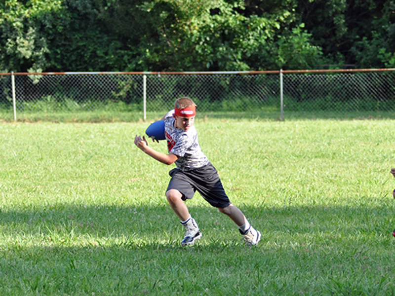 Donny Waters avoids a defender during the Copper Basin youth sports football conditioning Thursday, July 16.