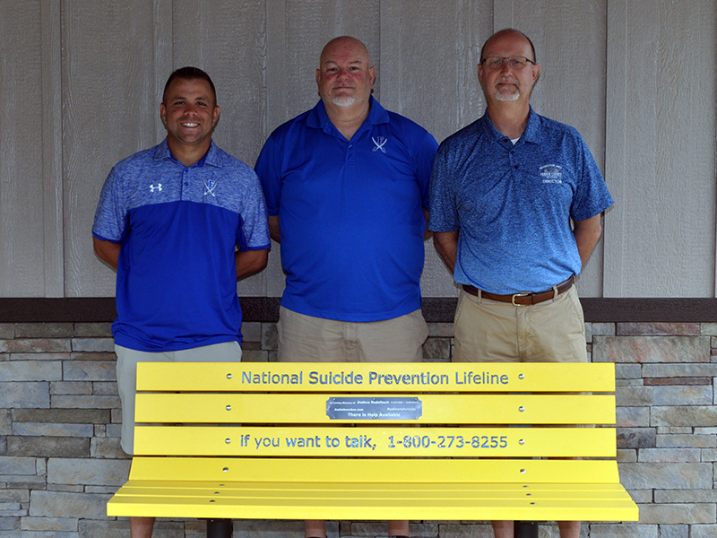 Josh’s Benches for Awareness Corporation recently donated a bench to the Fannin County Recreation Center. The bench provides the easily accessible hotline number for those needing help. Shown with the bench are, from left, Recreation Center athletic coordinators Tim Towe and John Spargo and Recreation Center Director Eddie O’Neal.