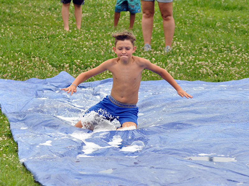 Reece Hughes slides down the slip-n-slide Wednesday, July 8, at the Fannin Recreation Center’s summer camp.