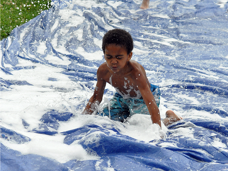 Jamel Johnson dives down the slip-n-slide at the Fannin Recreation Center’s summer camp, Wednesday, July 8.