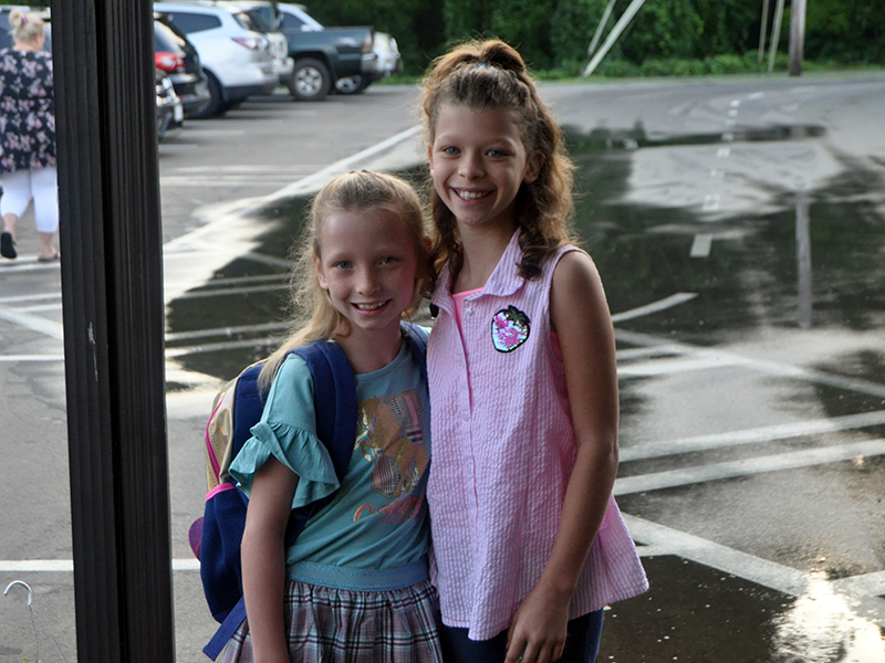 Fourth grader Desiray Park, left, and fifth grader Trinity Parker smile as they go to class during the first day of school at West Fannin Elementary School Friday, August 7.