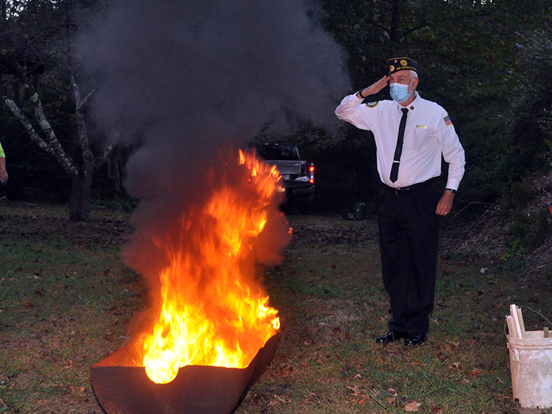 Veteran Steve Strickland renders a salute while American flags are retired Tuesday, October 20.