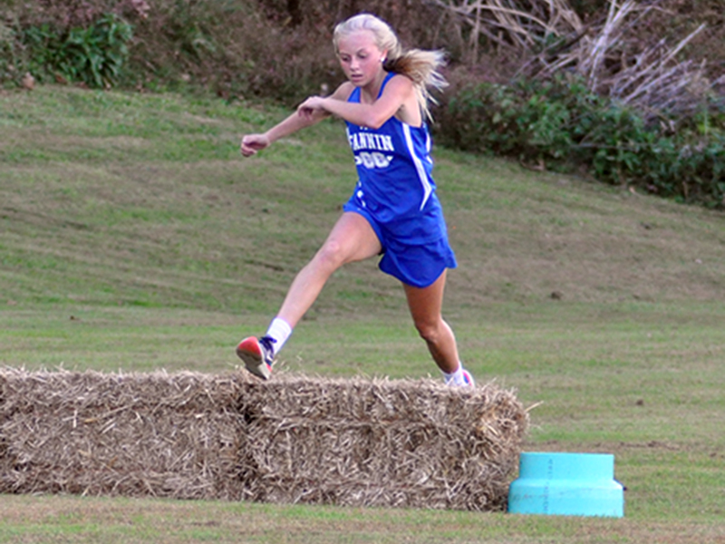 Carlee Holloway hurdles an obstacle during the Lady Rebels cross country meet Wednesday, October 21.